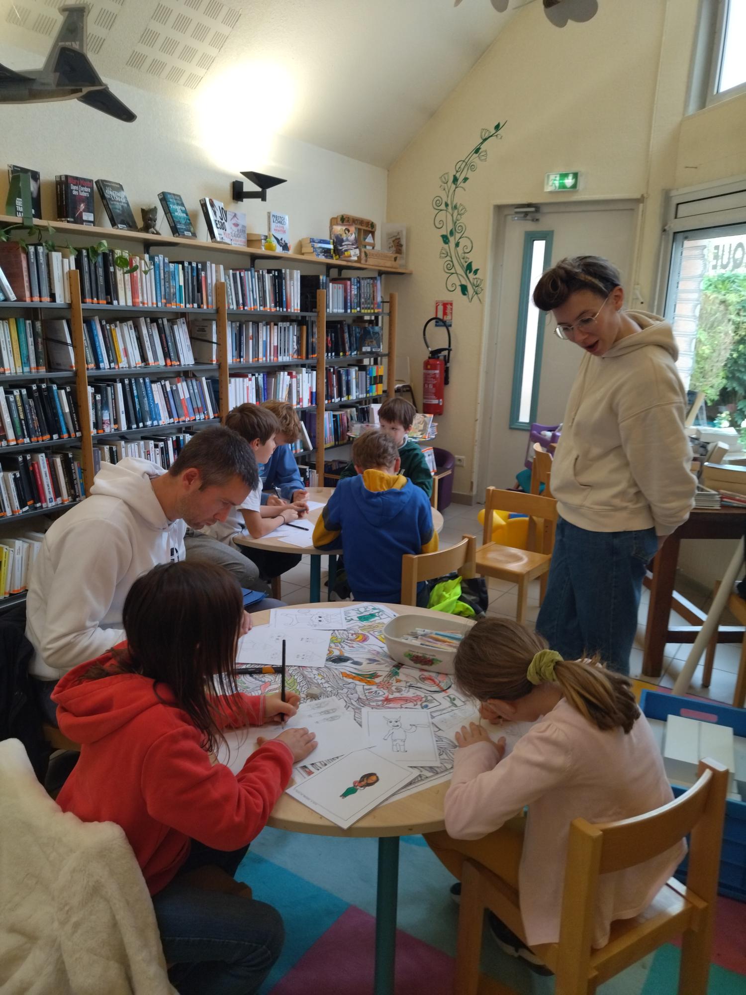 L'illustratrice encadre enfants et adultes pour l'atelier 